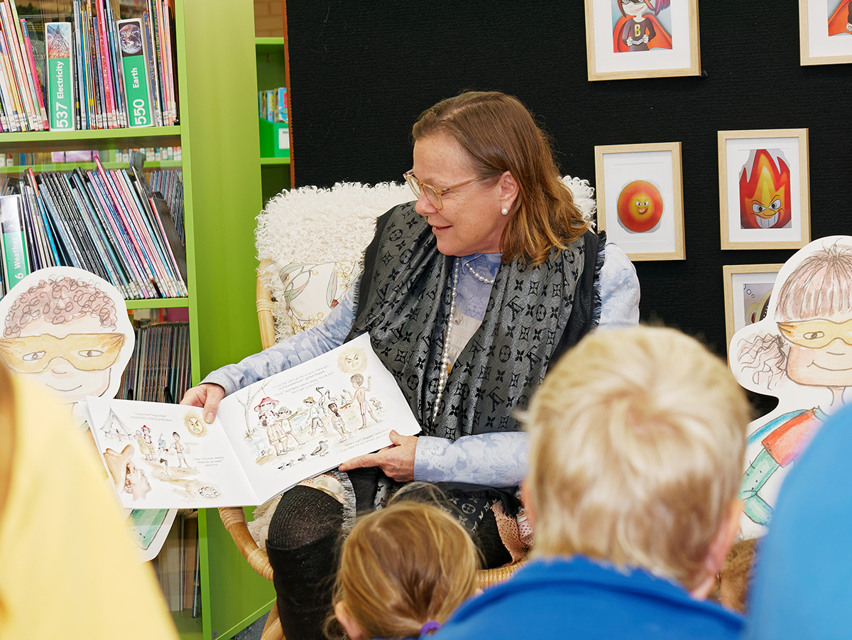 Professor Fiona Wood reading a Ben and Bella Burnsafe Superheroes book to students.