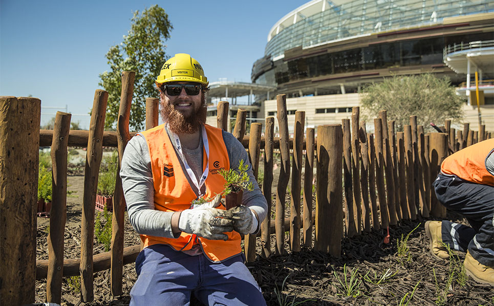 Chevron volunteer planting seedlings in the Chevron Parkland at the new Perth Stadium precinct.