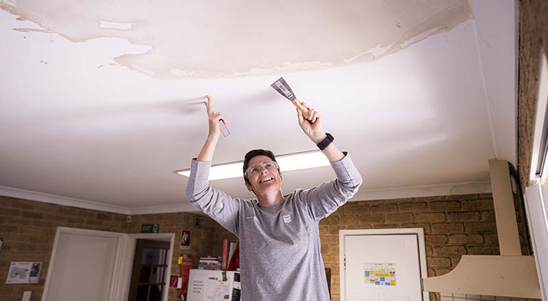 Members of Chevron Australia's Women Network doing volunteer paint preparation work at a Zonta House refuge.